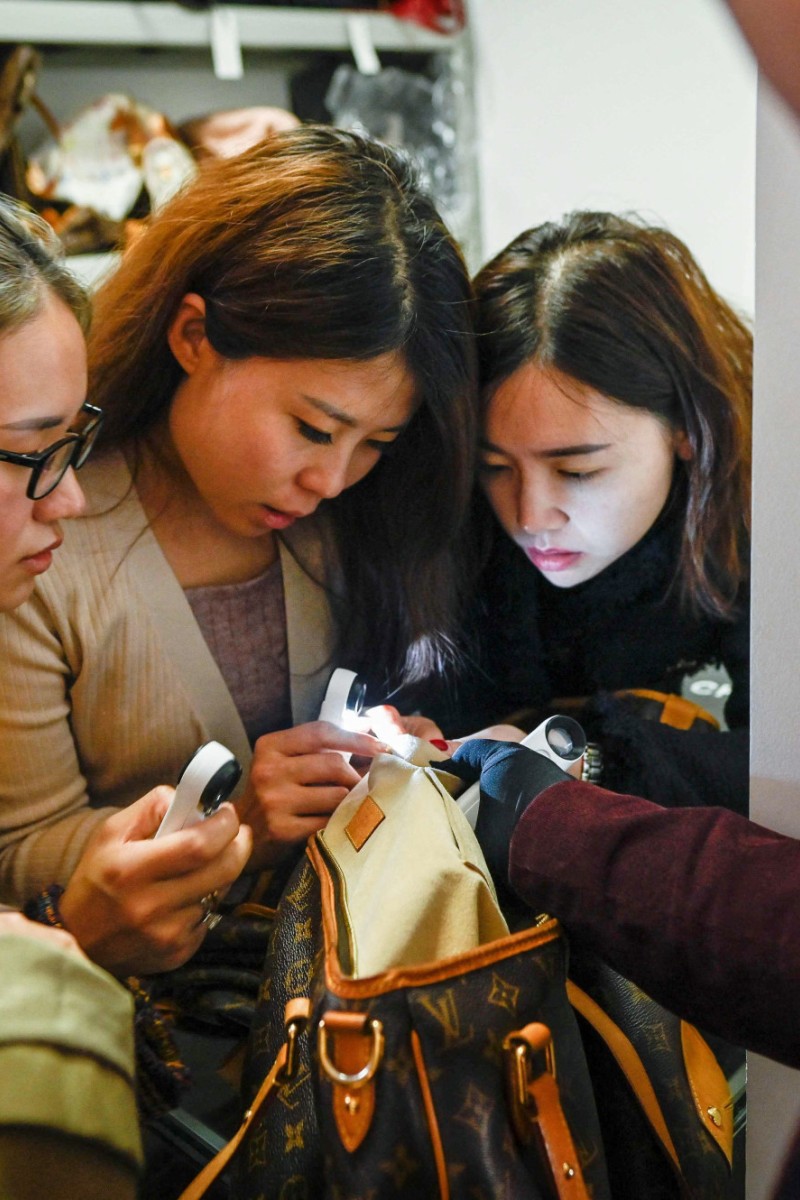 FILE--A young woman checks a second-hand Louis Vuitton (LV