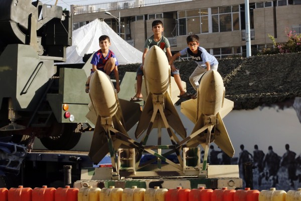 Iranian children sit on short-range missiles in a street exhibition celebrating “Defence Week” at the Baharestan Square in Tehran, Iran, on September 25. Iranian nuclear negotiations are set to resume on November 29. Photo: EPA-EFE