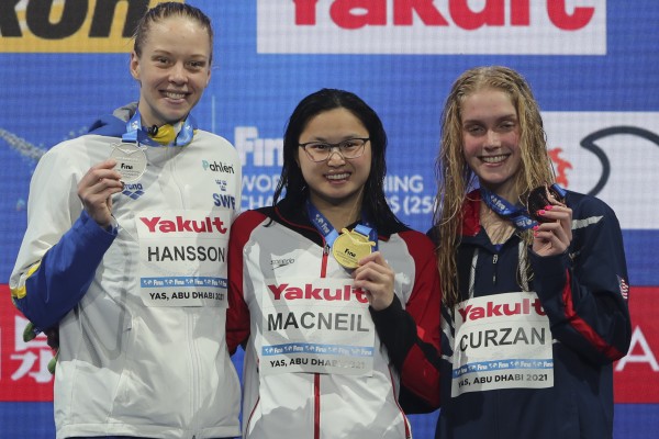 Frome the left, Louise Hanson of Sweden, silver, World Swimming Championships 100m butterfly event gold medal winner Margaret MacNeil of Canada (centre) with silver medallist Louis Hanson (left) of Sweden and bronze medallist Claire Curzan (right) of the US in Abu Dhabi. Photo: AP Frome the left, Louise Hanson of Sweden, silver, World Swimming Championships 100m butterfly event gold medal winner Margaret MacNeil of Canada (centre) with silver medallist Louis Hanson (left) of Sweden and bronze medallist Claire Curzan (right) of the US in Abu Dhabi. Photo: AP