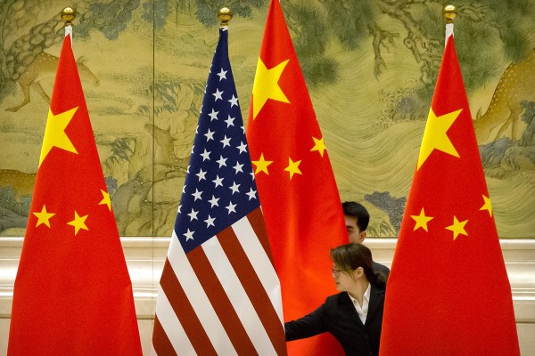 Staffers adjust flags before negotiations between US and Chinese trade representatives in Beijing in 2019. Photo: AP