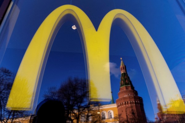 A logo of the McDonald’s restaurant and the Kremlin’s tower seen through a window. Photo: Reuters