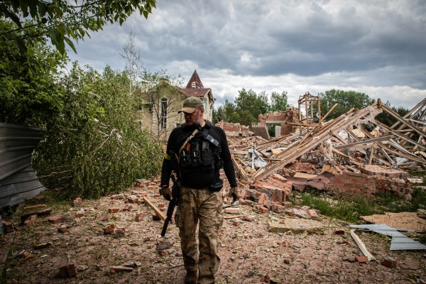 A Ukrainian territory defence soldier walks past the ruins of a building hit by shelling in the separatist region of Donbas. Photo: dpa
