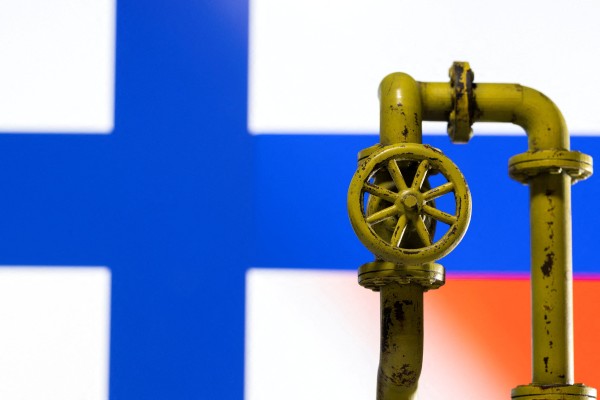 A model of a natural gas pipeline is seen in front of displayed Finnish and Russian flag colours. Photo: Reuters