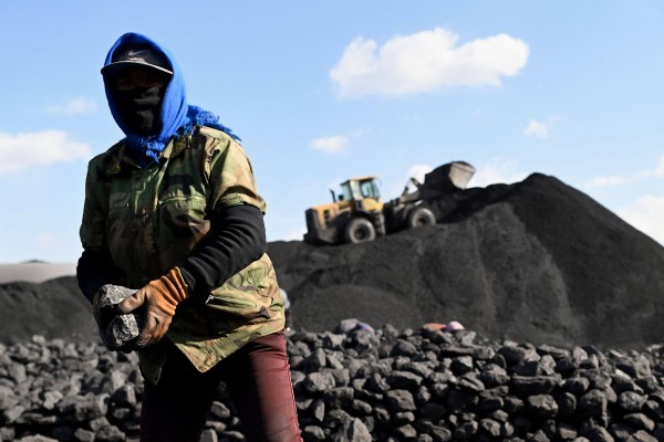 A worker sorts coal near a coal mine in Datong, in China’s northern Shanxi province on November 3, 2021. Photo: AFP
