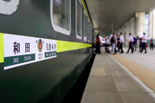 Passengers board the first train on the new service at Hotan station in Xinjiang on Thursday. Photo: Xinhua
