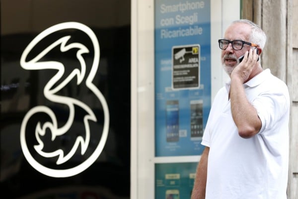 A pedestrian speaks on a mobile handset outside a 3 Italia mobile phone store, operated by CK Hutchison Holdings in Rome, Italy, on Monday, Aug. 10, 2015. Photo: Bloomberg