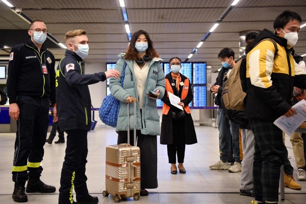 Passengers on a flight from China wait to have their Covid-19 vaccination documents checked after arriving at the Paris-Charles-de-Gaulle airport on Sunday. Photo: AFP
