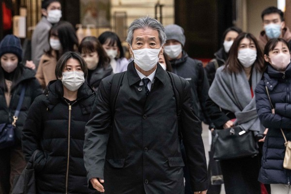 People wearing face masks cross a street in Tokyo last month. Photo: AFP