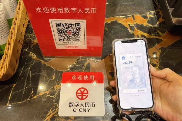 A customer makes a payment using China’s digital yuan, or e-CNY, at the Wangfujing Department Store in Beijing. Central bank digital currencies allow central banks to retain control while providing a financial system that avoids scams. Photo: Getty Images