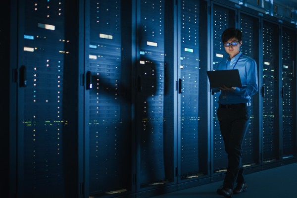 A technician inspects a row of server racks used for cloud computing. Photo: Shutterstock