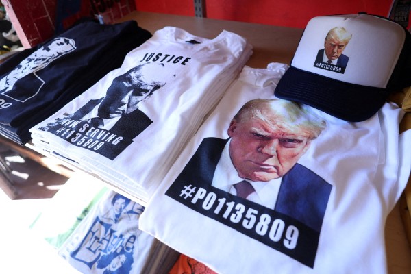 T-shirts and hats featuring Donald Trump’s mugshot. Photo: Reuters