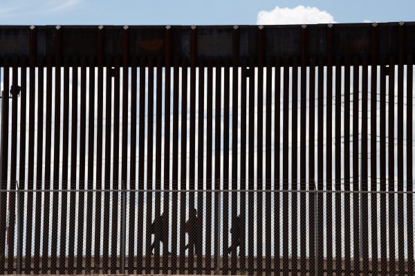 Migrants walk along the Mexico-US border wall to turn themselves in to the US Border Patrol in El Paso, Texas. Photo: Reuters