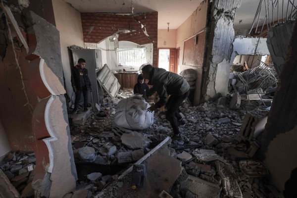 Palestinians inspect the damage to a building after Israeli bombardment in Rafah on March 25. Photo: AFP