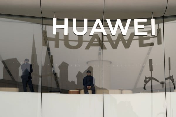 A visitor to the Huawei store in Beijing looks out the window near the logo for the Chinese telecoms equipment giant, March 26, 2024. Photo: AP 