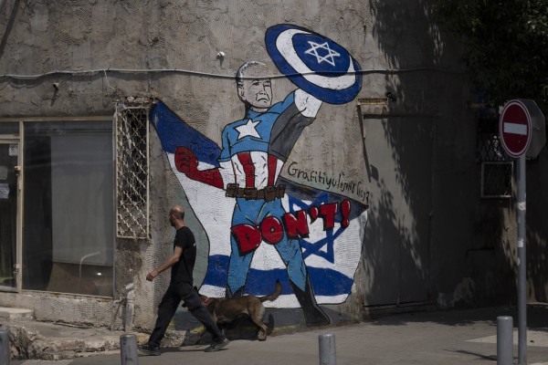A man walks past a mural depicting the US President Joe Biden as a superhero defending Israel on a street in Tel Aviv on April 14. Photo: AP