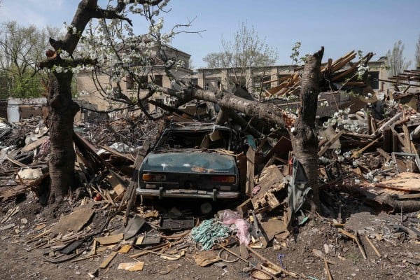 A destroyed car is seen in the yard of a house struck by missiles in the town of Selydove, in Ukraine’s Donetsk region, on Friday. Photo: AFP