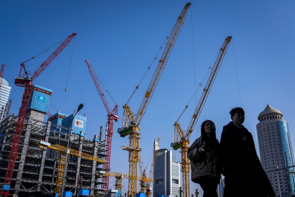 A young couple walk by a construction site in Beijing on March 2, 2024. Photo: AP