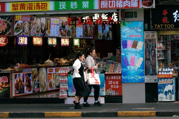 People walk past restaurants on a street in Shanghai on April 15, 2024.Photo: EPA-EFE