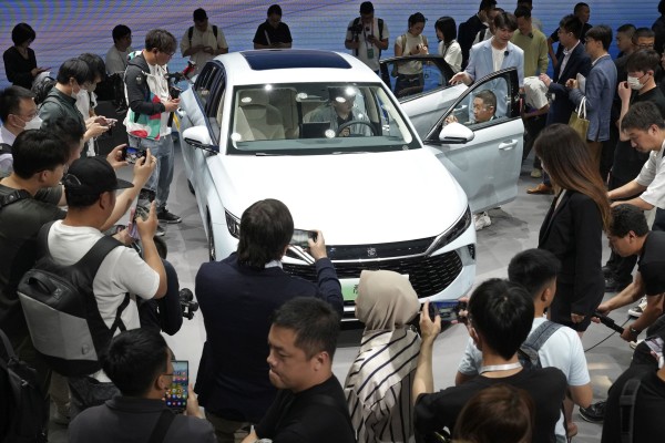 Visitors take a closer look at BYD’s new plug-in hybrid model at the Beijing International Automotive Exhibition on April 25. Photo: Kyodo