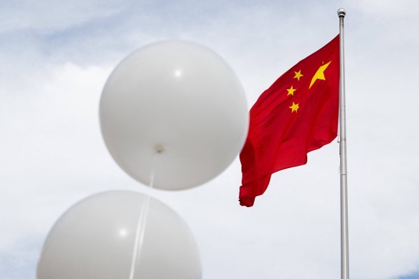 Two white balloons float near the Chinese flag during a demonstration outside the Chinese embassy in Washington in February 2023. Photo: AFP