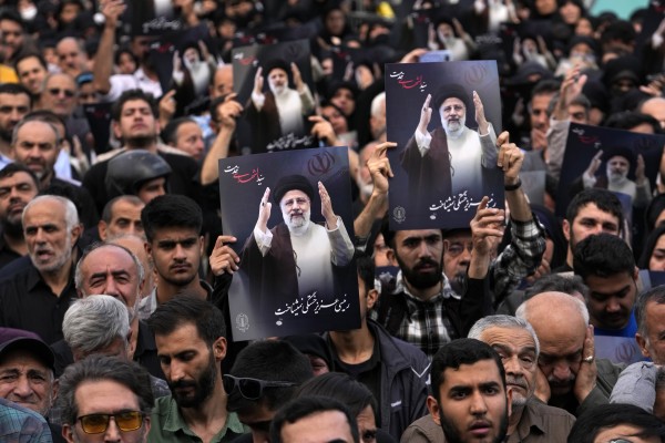 People hold up posters of President Ebrahim Raisi in downtown Tehran, Iran, on Monday. Photo: AP