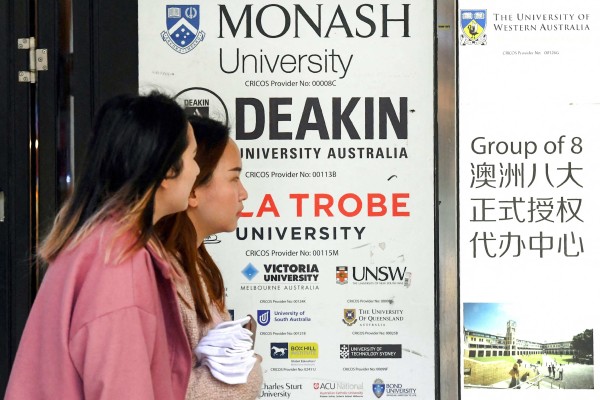 Women walk past signage advertising Australian universities in Melbourne’s central business district. Photo: AFP Women walk past signage advertising Australian universities in Melbourne’s central business district. Photo: AFP