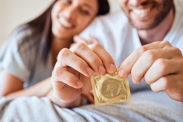 A man opens a condom. On Monday, a lawsuit was filed in Manhattan federal court claiming condoms made by Trojan are not safe because they contain toxic chemicals which have been linked to cancer. Photo: Shutterstock