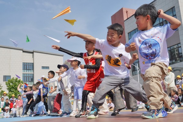 Students fly paper airplanes at a kindergarten in eastern China. Chinese lawmakers are reportedly considering proposals to provide free preschool education as part of a campaign to convince parents to have more children. Photo: Getty Images