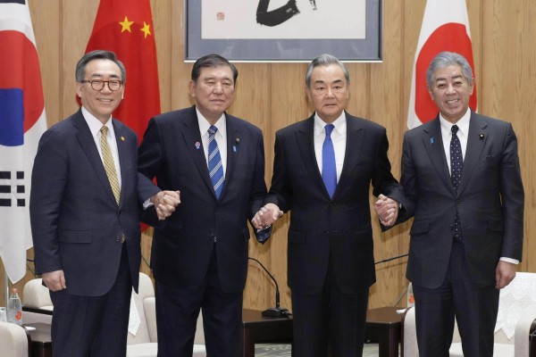 From the left, South Korean Foreign Minister Cho Tae-yul, Japanese Prime Minister Shigeru Ishiba, Chinese Foreign Minister Wang Yi and Japanese Foreign Minister Takeshi Iwaya join hands at the prime minister’s office in Tokyo on March 21. Photo: Kyodo