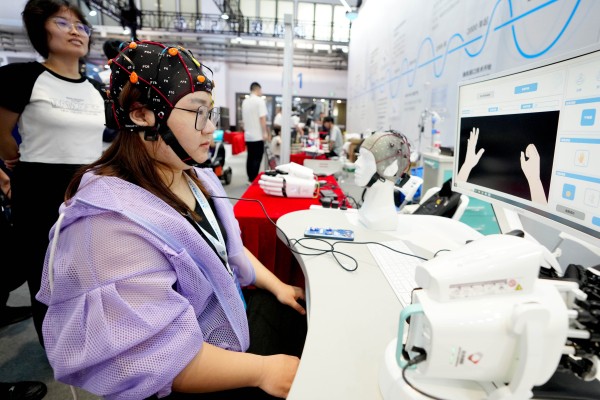 A staff member demonstrates a brain-computer interface for post-stroke rehabilitation at the World Robot Conference in Beijing, August 16, 2023. Photo: Xinhua