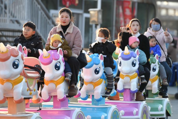 Children ride with adults in a park in Fuyang, in east China’s Anhui province, on January 16. China said on January 17 that its population fell for the third year running in 2024, extending a downward streak after more than six decades of growth as the country battles a looming demographic crisis. Photo: AFP