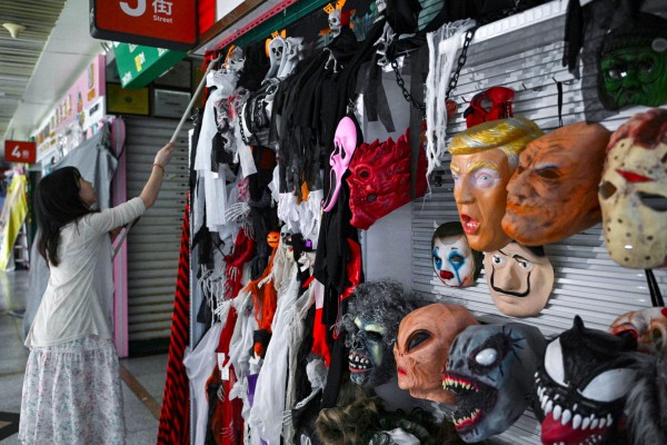 A vendor manages her shop selling Halloween masks at the Yiwu International Trade Market in China’s Zhejiang province on April 11. Photo: AFP