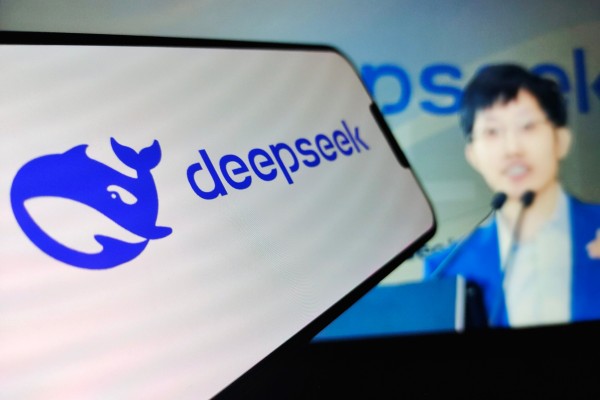 DeepSeek founder Liang Wenfeng, in the background, follows an open-source approach in AI development. Photo: Shutterstock
