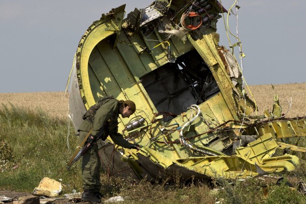 A pro-Russian rebel checks the wreckage of MH17 at the crash site on July 22, 2014. Photo: AP
