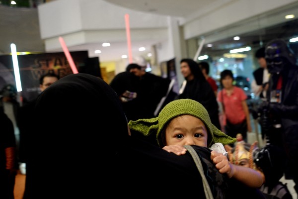 A Malaysian mother carries her child, dressed as baby Yoda, during a Star Wars-themed event in Kuala Lumpur. Photo: AFP