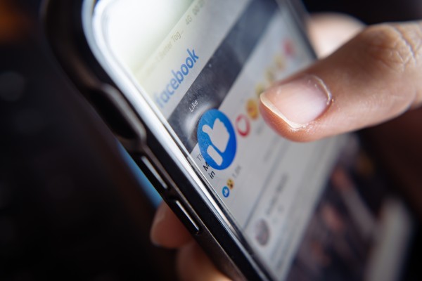 A person pressing “like” on a Facebook post. The thumbs up gesture has long ruled the internet and has had major impact on social media engagement – but where did it come from? Photo: Shutterstock