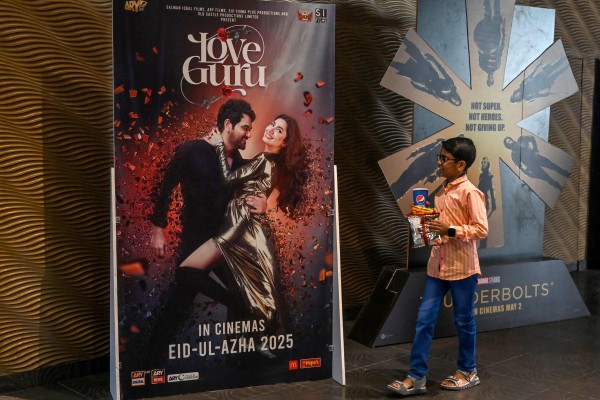 A young boy walks past a poster advertising the film “Love Guru”, featuring Pakistani actress Mahira Khan, in Lahore earlier this month. Photo: AFP