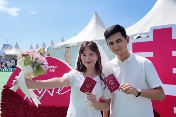 A couple poses for a photo at a marriage registry booth set up at a music festival in Urumqi, Xinjiang Uygur autonomous region. Photo: CCTV A couple poses for a photo at a marriage registry booth set up at a music festival in Urumqi, Xinjiang Uygur autonomous region. Photo: CCTV