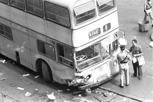 A China Motor Bus double-decker ploughed into a huge crowd in North Point, killing four people and injuring 46. Pictured here are policemen taking statements at the accident site. Photo: SCMP Archives