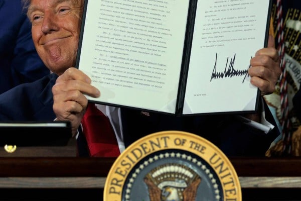 US President Donald Trump displays a signed executive order at an AI summit in Washington on Wednesday, where he discussed his administration’s strategy to outcompete China on artificial intelligence. Photo: AFP