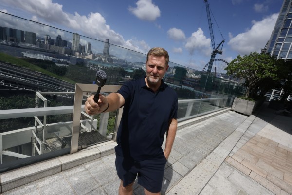Simon Squibb poses at IFC mall in Hong Kong’s Central neighbourhood. The businessman and content creator talks about expanding his mission to help people escape the “sell your time for money” system. Photo: Jonathan Wong