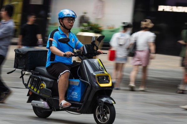 The signature blue uniform of Alibaba’s Ele.me riders will be replaced by an orange outfit under a revamp. Photo: Getty Images