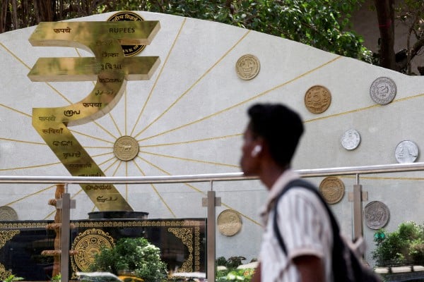 A person walks past an installation of the rupee logo and Indian currency coins outside the Reserve Bank of India’s headquarters in Mumbai on April 9. Photo: Reuters A person walks past an installation of the rupee logo and Indian currency coins outside the Reserve Bank of India’s headquarters in Mumbai on April 9. Photo: Reuters