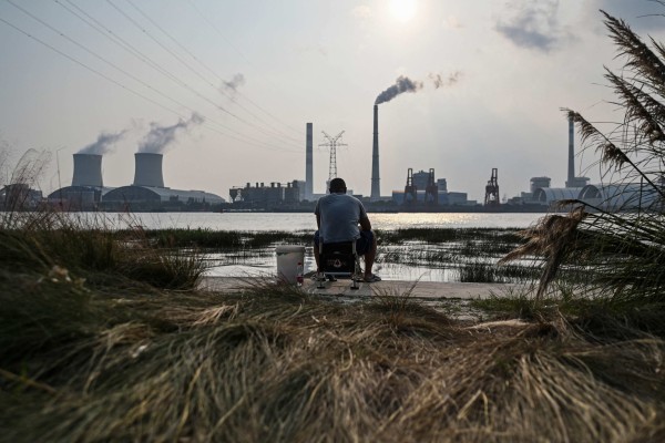 An angler fishes across from the Wujing Power Station in Shanghai. China won’t back Brazil’s key rainforest initiative for the time being. Photo: AFP An angler fishes across from the Wujing Power Station in Shanghai. China won’t back Brazil’s key rainforest initiative for the time being. Photo: AFP