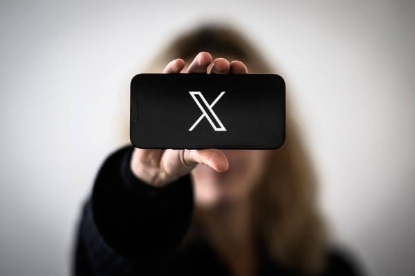 A woman holds a smartphone displaying the logo of social network X. Thousands of users reported issues with the platform on Tuesday. Photo: AFP A woman holds a smartphone displaying the logo of social network X. Thousands of users reported issues with the platform on Tuesday. Photo: AFP