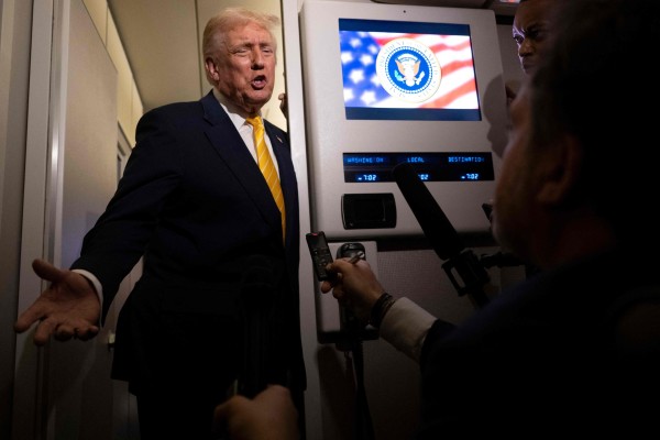 US President Donald Trump speaks to reporters on board Air Force One on Friday while in flight from Washington to West Palm Beach International Airport. Photo: Getty Images via AFP
