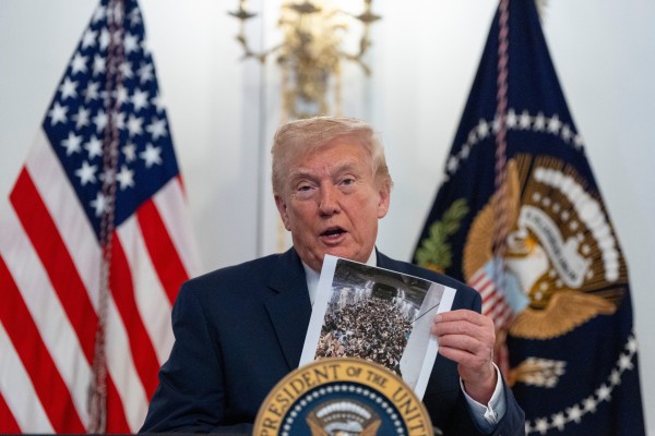 US President Donald Trump holds up a photo as he speaks to troops via video from his Mar-a-Lago estate on Thanksgiving. Photo: AP US President Donald Trump holds up a photo as he speaks to troops via video from his Mar-a-Lago estate on Thanksgiving. Photo: AP