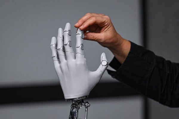 A journalist touches a hand made for Xpeng’s second-generation Iron humanoid robot at the company’s Guangzhou headquarters on November 6. Photo: AFP A journalist touches a hand made for Xpeng’s second-generation Iron humanoid robot at the company’s Guangzhou headquarters on November 6. Photo: AFP