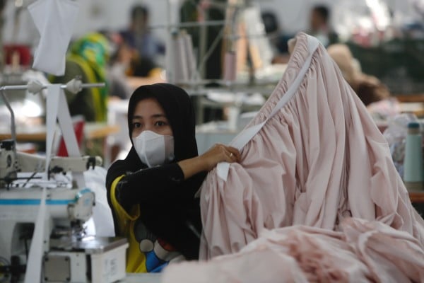 A worker holds a piece of clothing at a factory in Depok, Indonesia, on April 25, 2022. Photo: EPA-EFE/ADI WEDA A worker holds a piece of clothing at a factory in Depok, Indonesia, on April 25, 2022. Photo: EPA-EFE/ADI WEDA