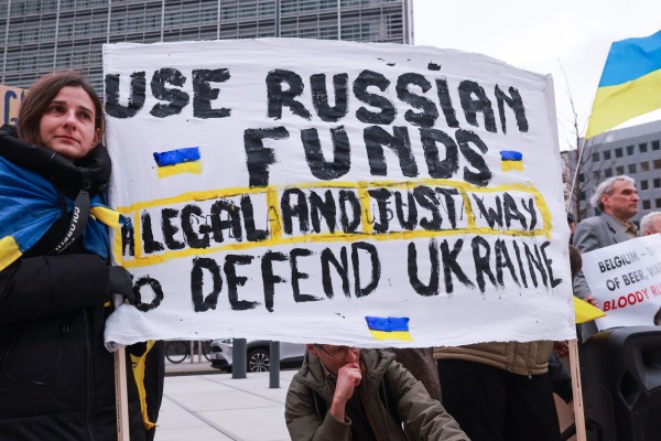 Ukrainians hold placards during a protest demanding the use of the frozen Russian assets in Brussels, Belgium, on Friday. Photo: EPA